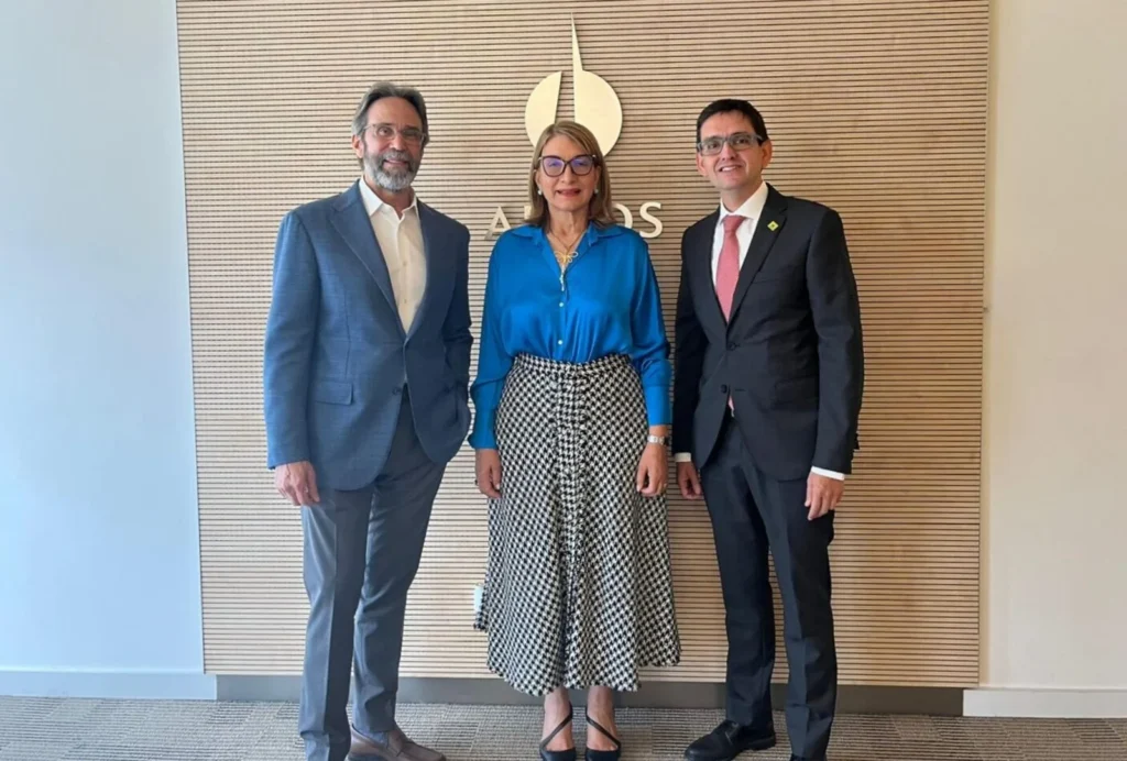 Tres representantes posan de pie ante el mural con el logo Argos tras el anuncio de la alianza