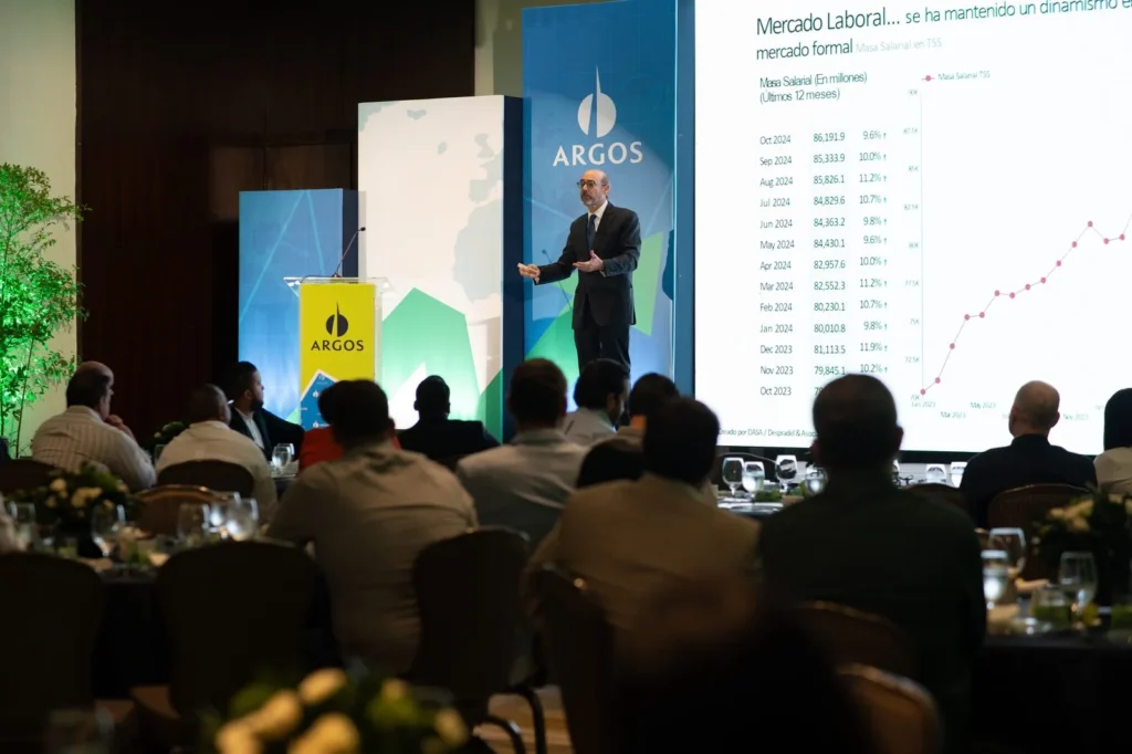 Ponente ante el auditorio de Panorama Económico Argos 2025, con el análisis del mercado laboral proyectado en pantalla